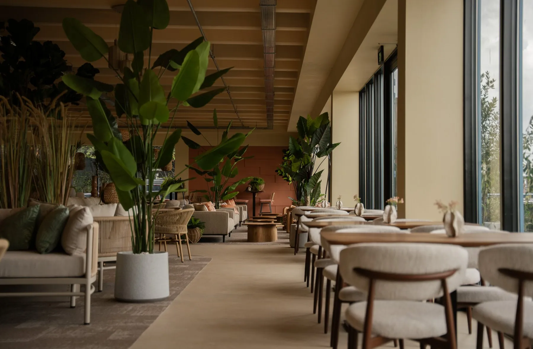 Lichte zaal met tafels en planten bij DOKSIDE